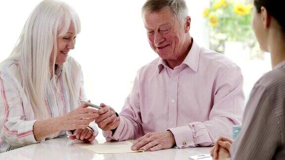 成年夫妇与女性理财顾问见面并在家签署文件