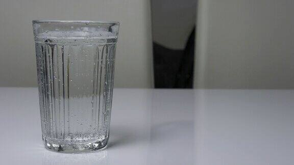 矿泉水饮用水在一个白色的玻璃杯表面饮用水在一个玻璃杯特写