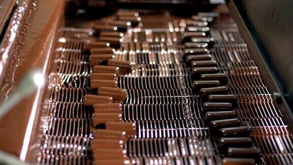 巧克力的生产被液态巧克力覆盖的糖果在传送带上