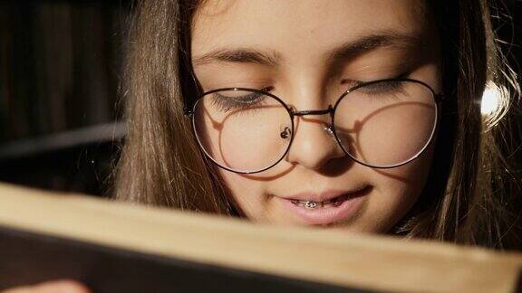 戴眼镜的女孩在图书馆看书特写