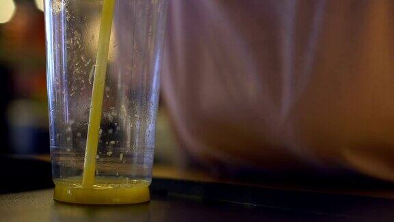 口渴的咖啡顾客喝着橙汁用塑料吸管喝着柑橘鸡尾酒