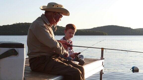 爷爷和孙子在夏天的日落钓鱼