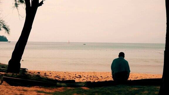一个无名男子坐在沙滩上