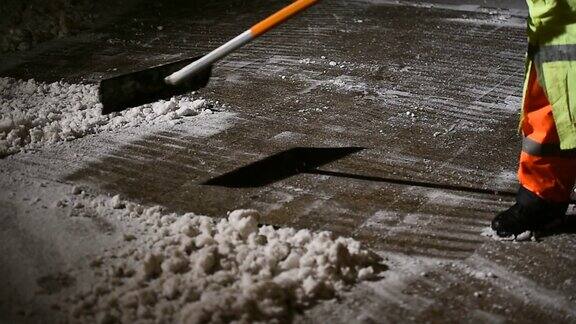 晚上下雪时清洁工会手动清除人行道上的新雪