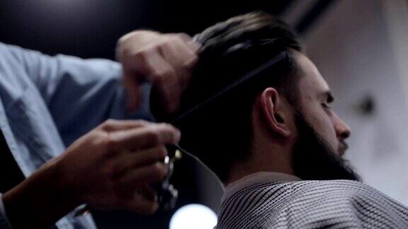 男理发师和一个男客户在理发店理发师用剪刀理发