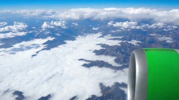美丽的景色透过飞机的窗户飞机飞过云层和山脉