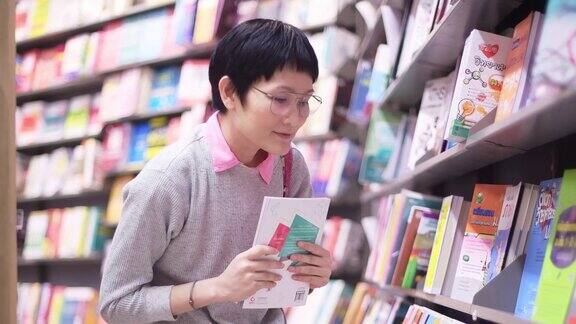 亚洲妇女在购物中心买书