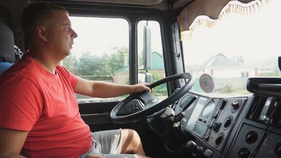 卡车司机手握方向盘控制汽车驶向目的地驾驶卡车穿越乡村的人在乡村公路上行驶的卡车司机物流运输理念