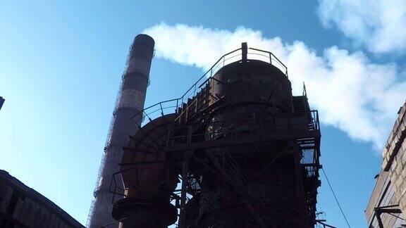 钢铁厂的结构以白烟缭绕的管道为背景
