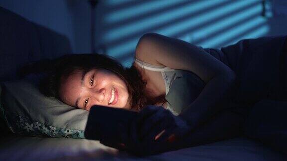 女人晚上在床上用智能手机