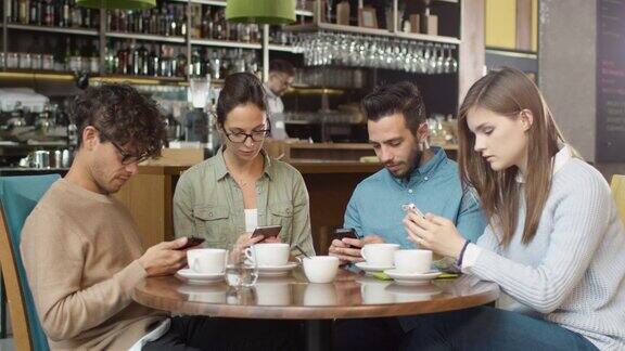 一群年轻的混血儿在咖啡店里使用手机