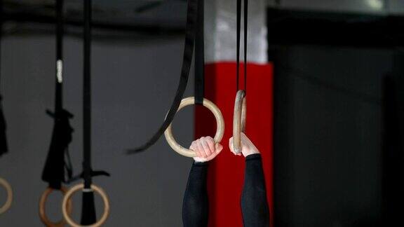 在健身房健身训练中年轻人在吊环上锻炼