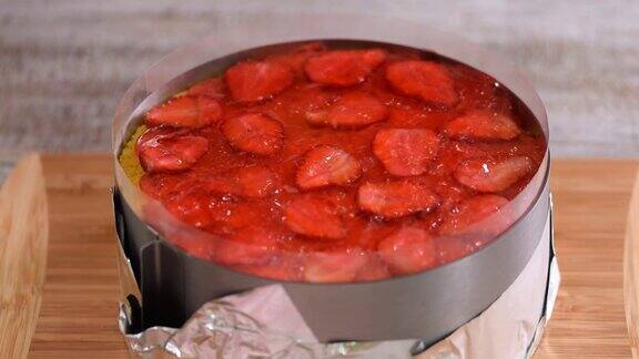 正在做草莓果冻蛋糕的女人将红色果冻倒在蛋糕上