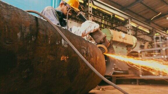 钢管厂工人正在打磨半成品钢管