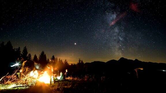 朋友们围坐在篝火旁在星河星河的夜晚时光流逝