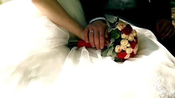 新娘和新郎捧着新娘花束