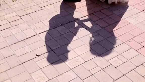 新婚夫妇在柏油路上的影子剪影