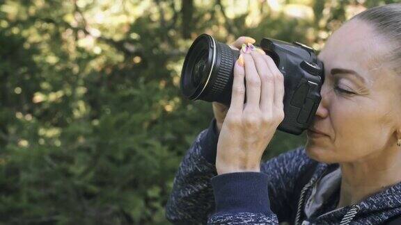 游客在森林中拍摄风景一名白人女子近距离射击女孩用无反光镜单反相机拍摄视频