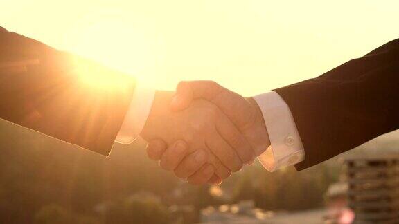 特写:日落时分企业家在达成交易时握手的细节