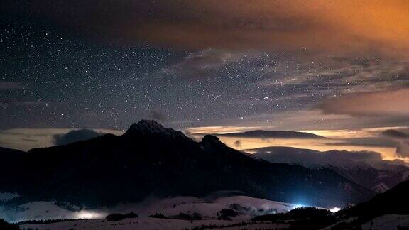 全景星空与星星和缤纷的云在冬季山与薄雾在山谷时间流逝