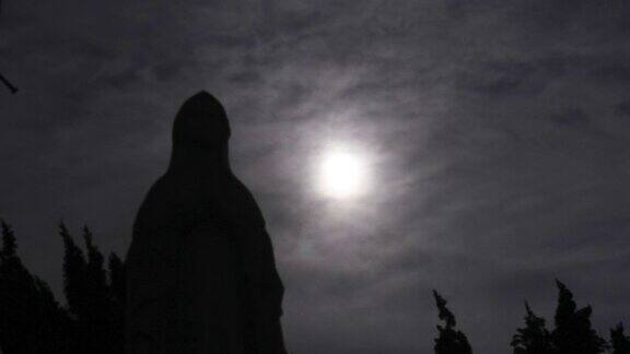 在墓地的圣母玛利亚和月亮的剪影场景