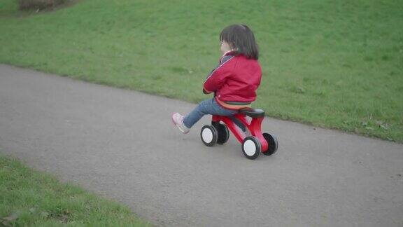 小女孩在户外公园玩自行车