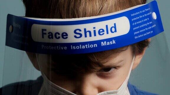 严肃的小男孩戴着防护面罩和面罩