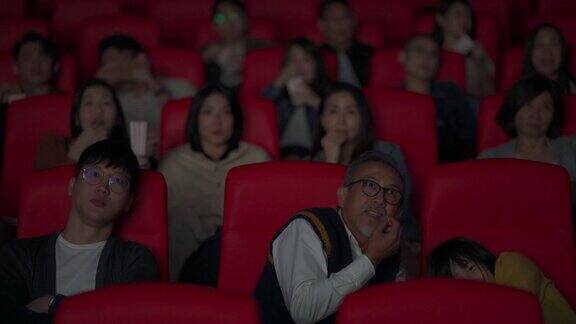 一群亚洲华人在电影院看恐怖的恐怖片