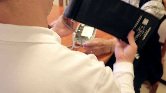 医疗保健工作者在家中测量一位老年妇女的血压