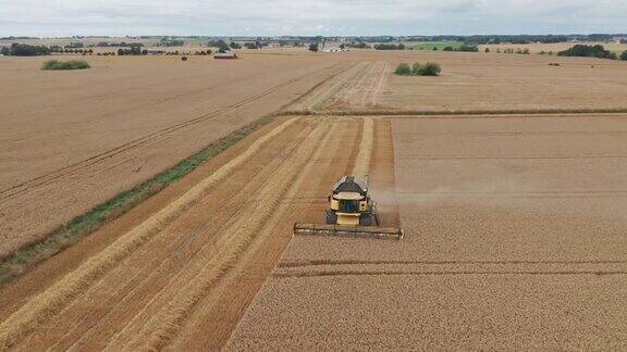 鸟瞰图广阔的农田与收割机在瑞典收获作物