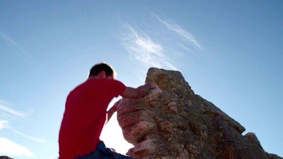 攀岩者用太阳耀斑到达巨石的顶峰