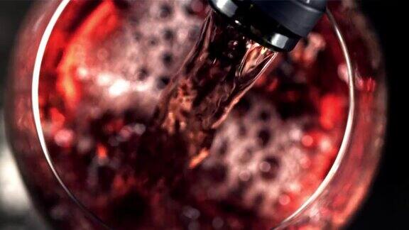 超级慢动作红葡萄酒与气泡倒进玻璃杯用高速摄像机以每秒1000帧的速度拍摄