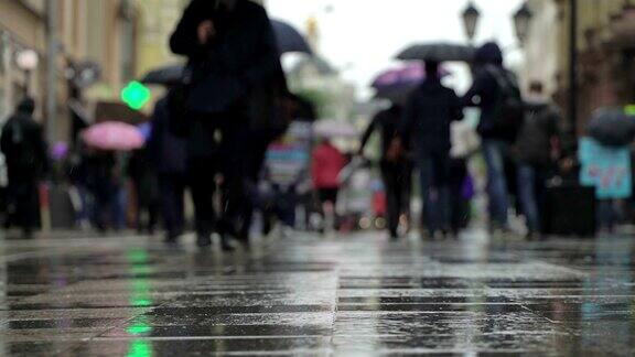 城市街道上的雨天背景真正的时间人们在雨中带着雨伞上下班模糊的散景自然背景