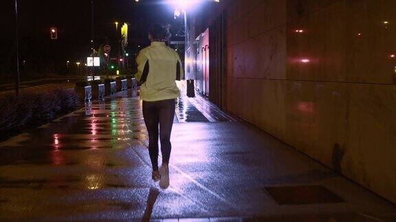 一位女士在一个雨夜的城市里慢跑