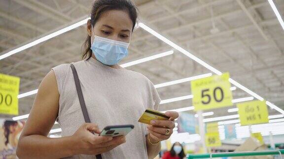 女人戴着防护面具在网上刷信用卡网上购物