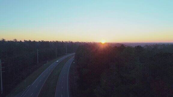 佛罗里达州塔拉哈西附近的森林公路在日出时被晨雾覆盖用静态摄像机拍摄无人机视频