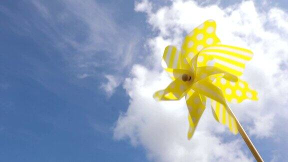 蓝色天空映衬着黄色的风车玩具夏天