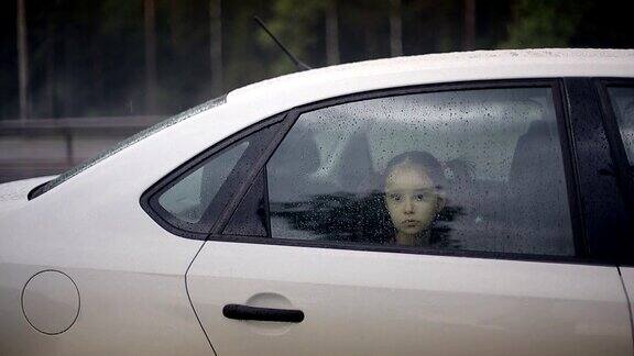 小女孩从车窗往外看