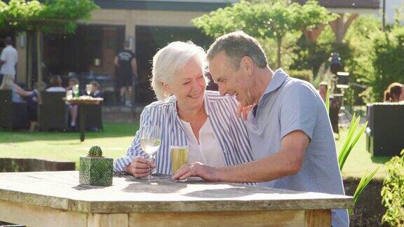 一对老年夫妇在酒吧享受夏日户外饮品