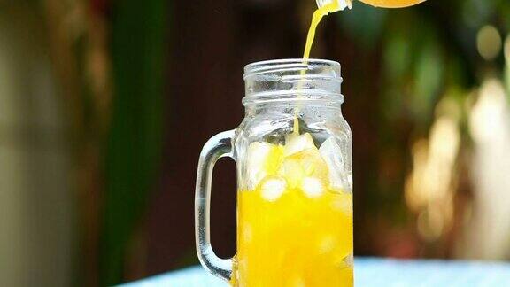 将橙汁倒入装有冰的罐子中