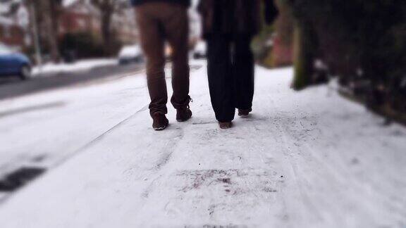 两个人在雪地里走背影特写脚