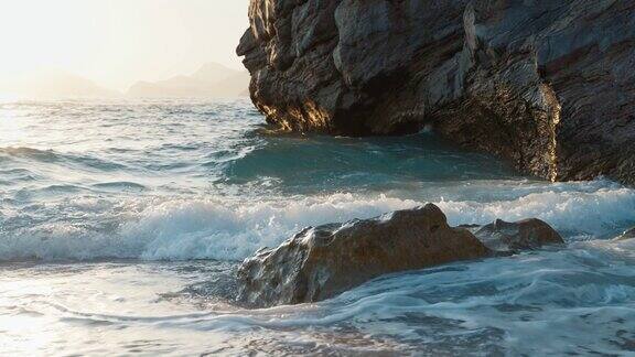 艺术海景镜头日落时海浪拍击岩石