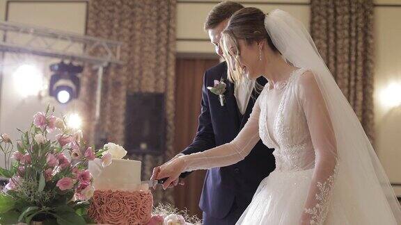 新娘和新郎正在切结婚蛋糕新婚夫妇切一块蛋糕