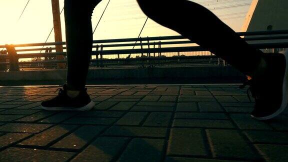 在阳光下的桥上行走的人的腿