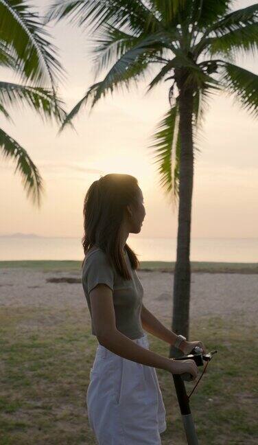一名女子骑着滑板车看海滩的美景