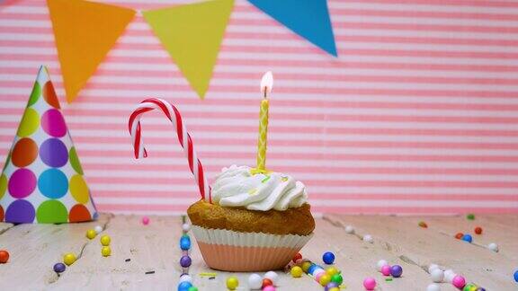 任何年龄的生日祝福拷贝空间美丽的视频背景快乐的生日粉红色的背景奶油纸杯蛋糕和蜡烛与火