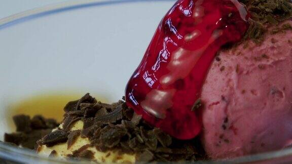 冰淇淋球被浇上了红色的果酱