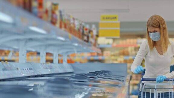 年轻女子戴着医用口罩打开冰箱取出冷冻食品一名妇女在超市购买冷冻食品在隔离期间购物新冠肺炎4kProRes