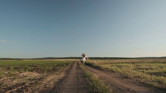 一个女孩带着麦穗在田野里散步和休息