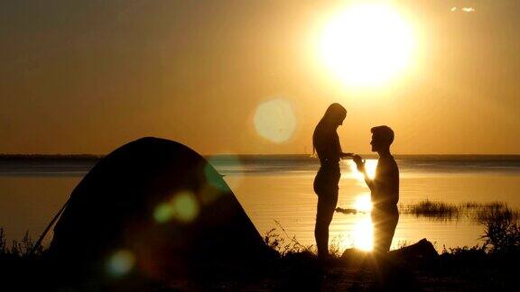 日落时分一个男人在海滩上向心爱的女人求婚